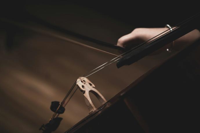 a violin being held by a person with a pair of scissors